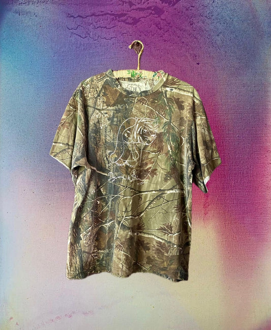 Camouflage-patterned t-shirt on a hanger against a colorful, textured background